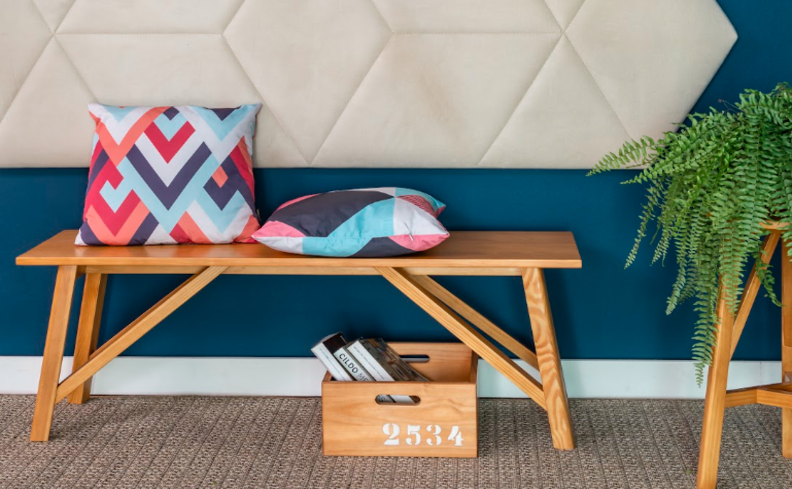 sapateiras estreita para hall de entrada com sapateira banco, caixa com revista, vaso com planta e um banquinho.
