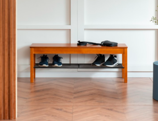 sapateira pequena para hall de entrada com uma sapateira banco, uma mesa de apoio azul e um vaso com flores.