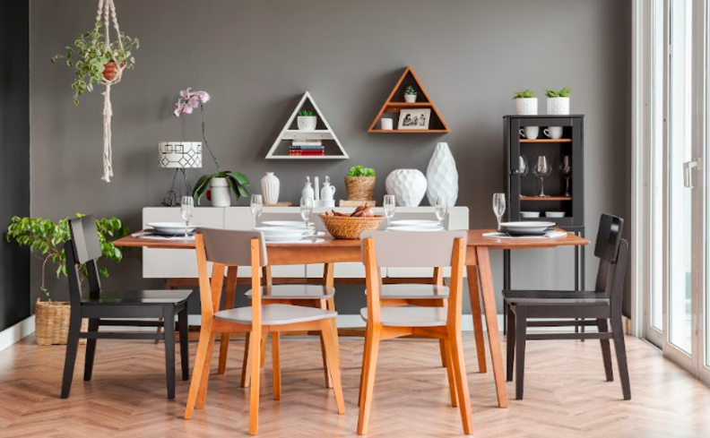 cristaleira de madeira na sala de jantar, além de mesa de jantar retangular, seis cadeiras, nichos em formato de triângulo e diversos itens de decoração.