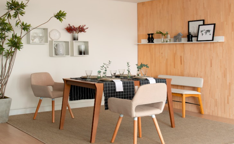 estilo moderno na decoração da sala de jantar com mesa retangular de madeira, duas cadeiras e um banco, estante e objetos decorativos com uma paleta de cores neutras.