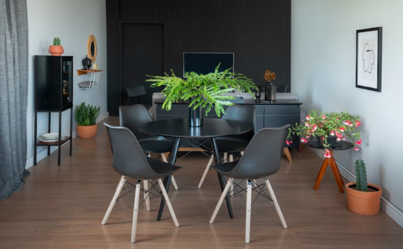 modelo de cristaleira de vidro e madeira preta na sala de jantar com uma mesa redonda e quatro cadeiras com pés palito.