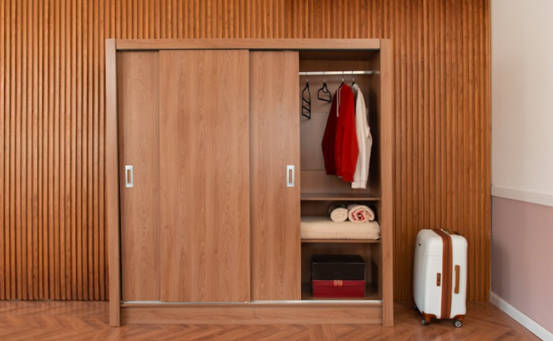 dicas de organização de guarda-roupa em um quarto com um modelo de portas de correr com diversas peças organizadas em cabides iguais para ter uma visualização mais prática e fácil no dia a dia.