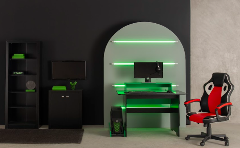 setup gamer com cadeira gamer vermelha e preta, mesa de computador preta e verde, estantes pretas e fitas de LED verdes ao fundo.