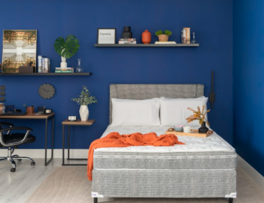 quarto de hóspedes e escritório com cama, escrivaninha, cadeira de escritório, prateleira e diversos itens decorativos para receber bem os convidados.