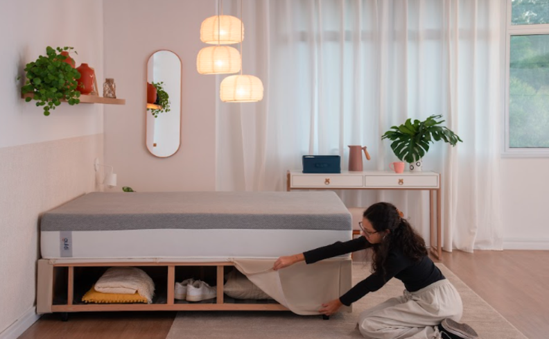 home office e quarto de hóspedes com escrivaninha, vasos com plantas, espelho e lustre pendente.