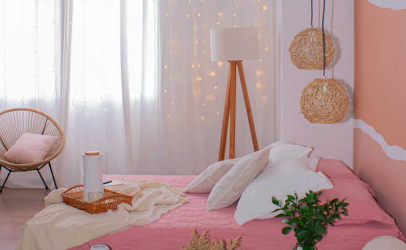 quarto de hóspedes com cantinho da leitura com cama em tons de rosa, luminária de chão, lustres pendentes e poltrona com almofada.