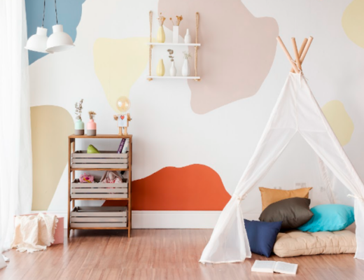 o que fazer nas férias em casa com atividades criativas para crianças como montar uma cabana no quarto com almofadas, parede colorida e um carrinho com diversos itens de pintura para toda a família se divertir.