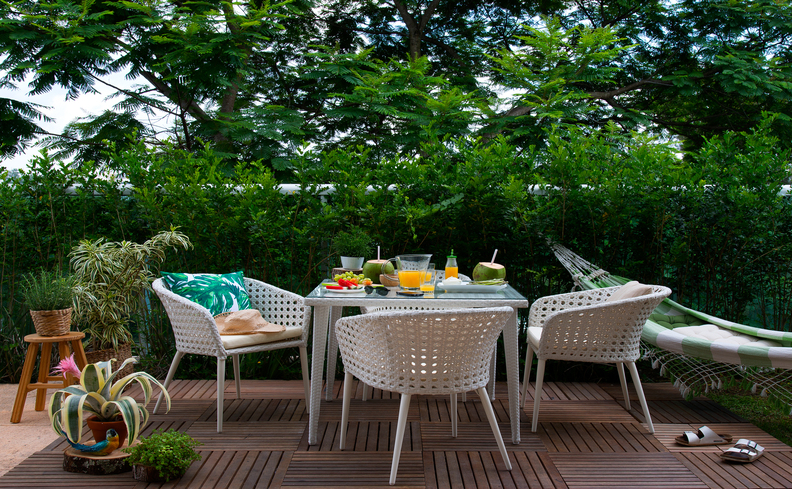 o que fazer nas férias em casa com as crianças no quinta com mesa, quatro cadeiras, rede, mesa com diversas comidas saborosas.