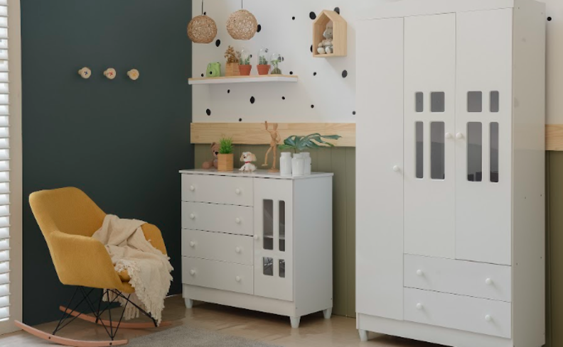 decoração quarto infantil com poltrona que balança amarela, manta, cômoda, guarda-roupa infantil, uma parede azul, prateleira e diversos itens decorativos.
