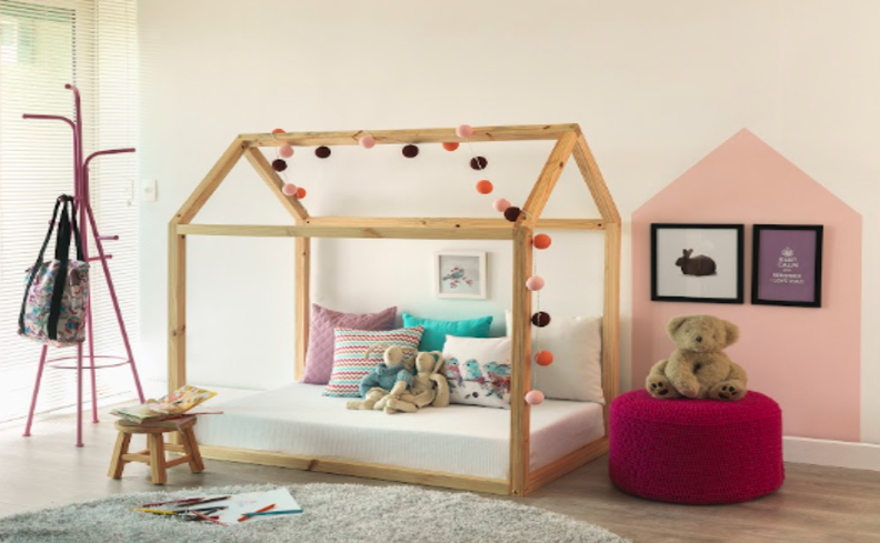 decorar quarto infantil menina com cama montessoriana de madeira, tapete, puff vermelho e cabideiro de chão.
