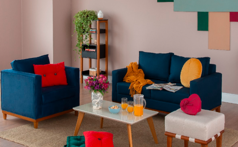 poltrona e sofá azul na sala de estar para ter uma decoração colorida, além de almofada amarela e vermelha, mesa de centro e diversos itens de decoração.