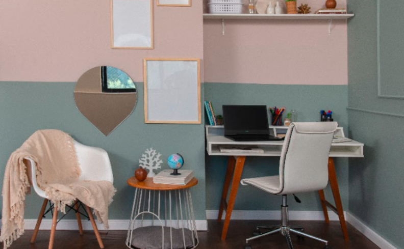 escritório em casa com escrivaninha, cadeira de escritório, poltrona, painel, quadros decorativos, espelho e mesa lateral.