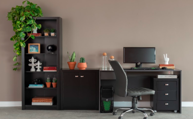 ideias de home office pequeno com escrivaninha preta com estante, além de cadeira de escritório, itens de decoração e livros.