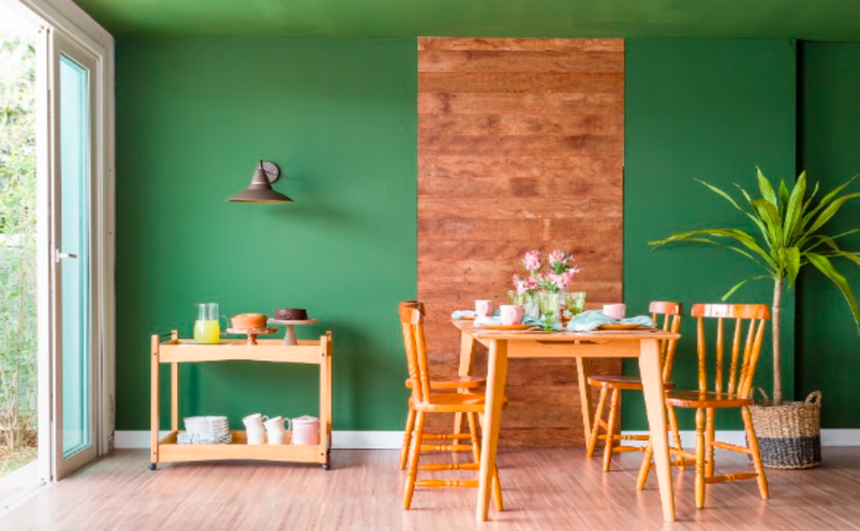 mesa de jantar extensível, com quatro cadeiras de madeira, aparador e diversos itens de decoração.