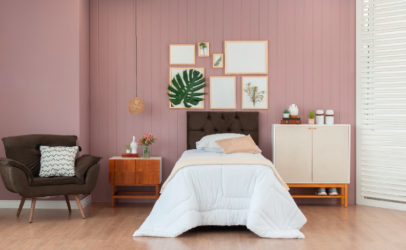 quarto Black Friday com cama de solteiro, mesa de cabeceira, cômoda pequena e poltrona marrom.